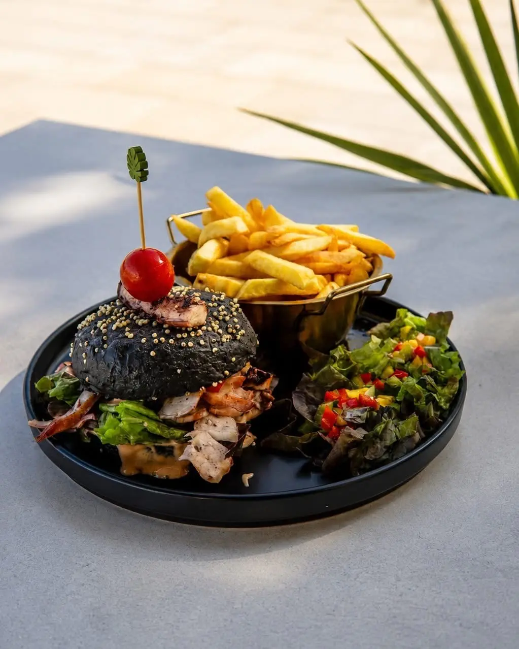 Burger au pain noir, frites et salade à La Sergerie